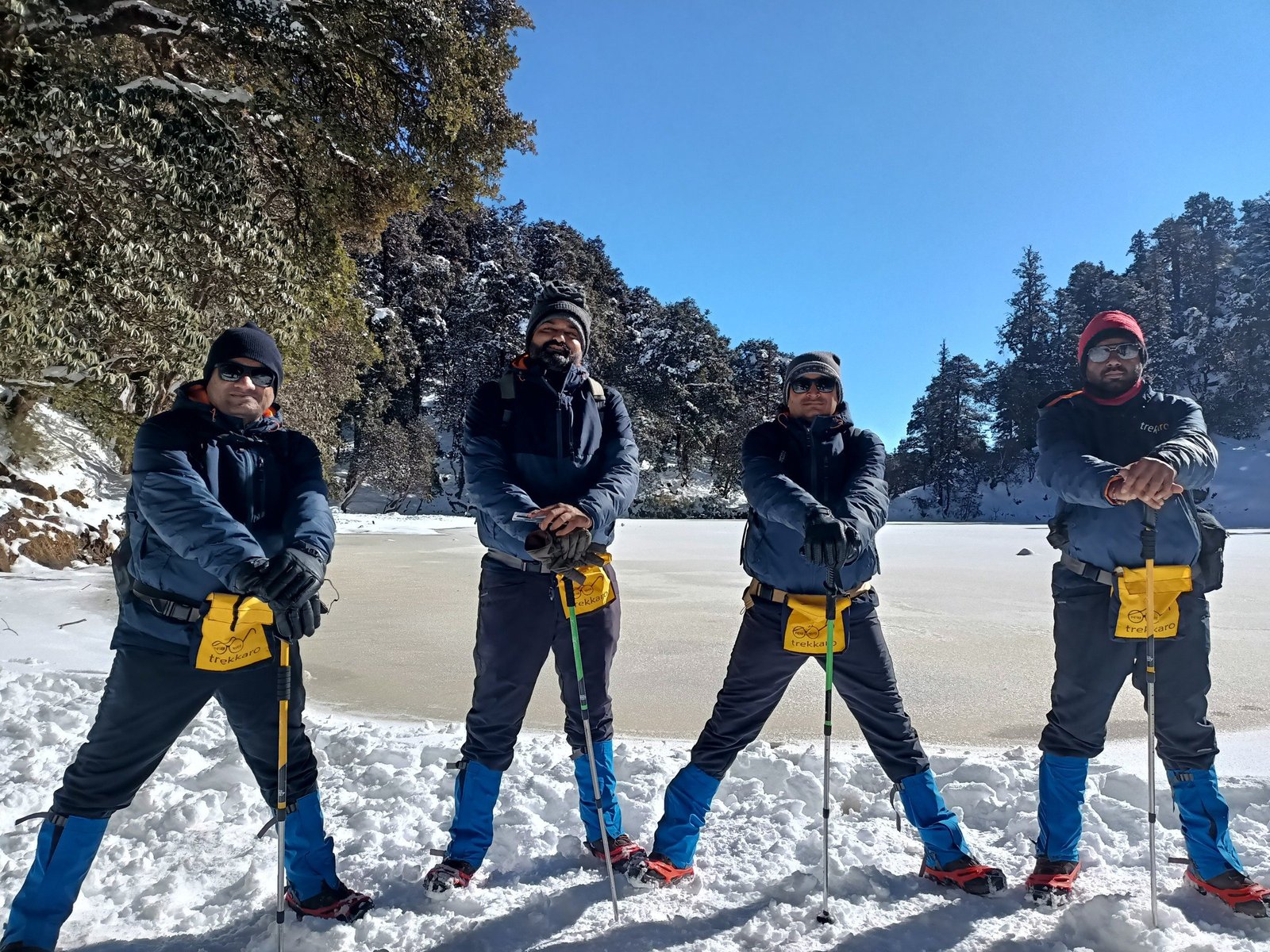 Trekkaro trekkers on the snow under a clear winter sky on the Brahmatal trek