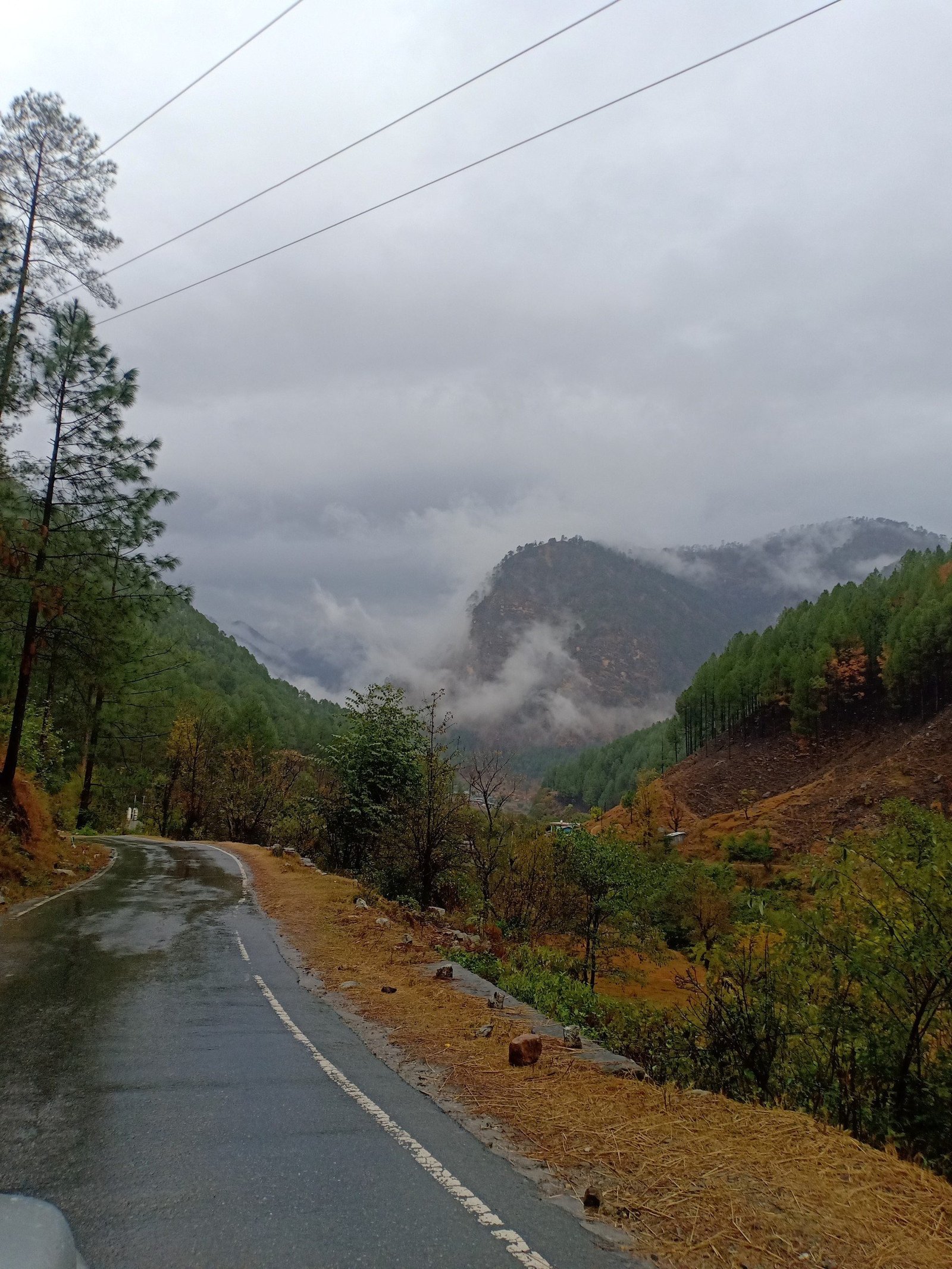 The mountain road through the valley under low cloud