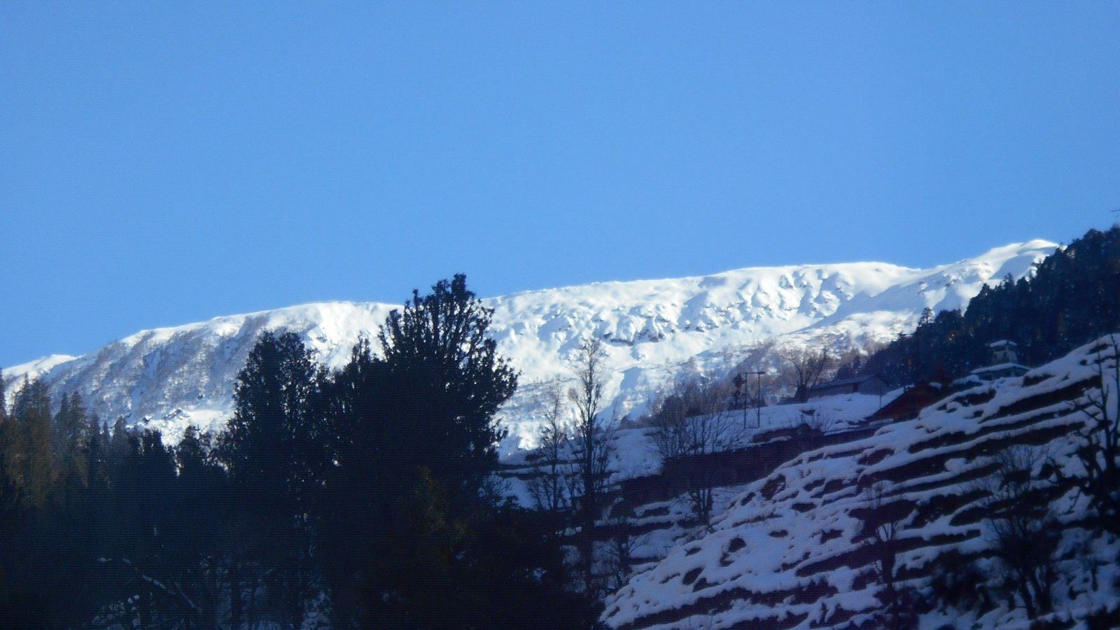 Snow ridge above terraced fields on the Gulabikantha trek route
