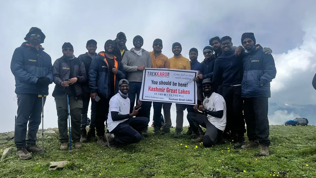 Trekkaro group holding a Kashmir Great Lakes sign on a high meadow