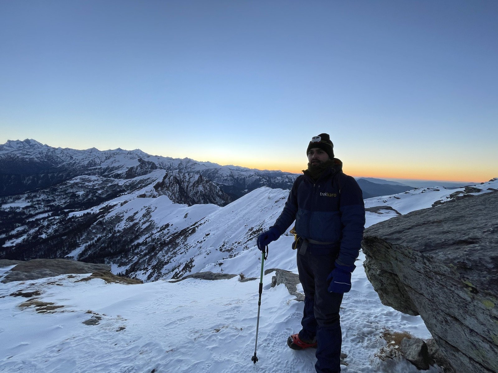 A Trekkaro trek leader on the snowy upper trail, with the ranges behind