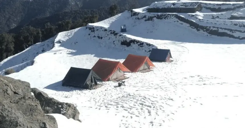 Nag Tibba base camp tents surrounded by fresh snow in January